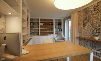 Innenansicht eines stilvollen Home Offices mit einer großzügigen Bibliothek...